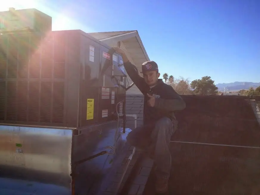 HVAC technician performing AC Tune-Up on a rooftop unit in Roanoke Rapids